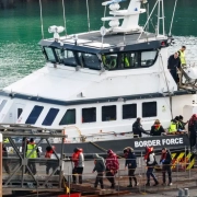 Pep[;e who have fled for their lives leaving a boat being met by Border Control.