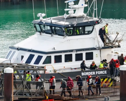 Pep[;e who have fled for their lives leaving a boat being met by Border Control.